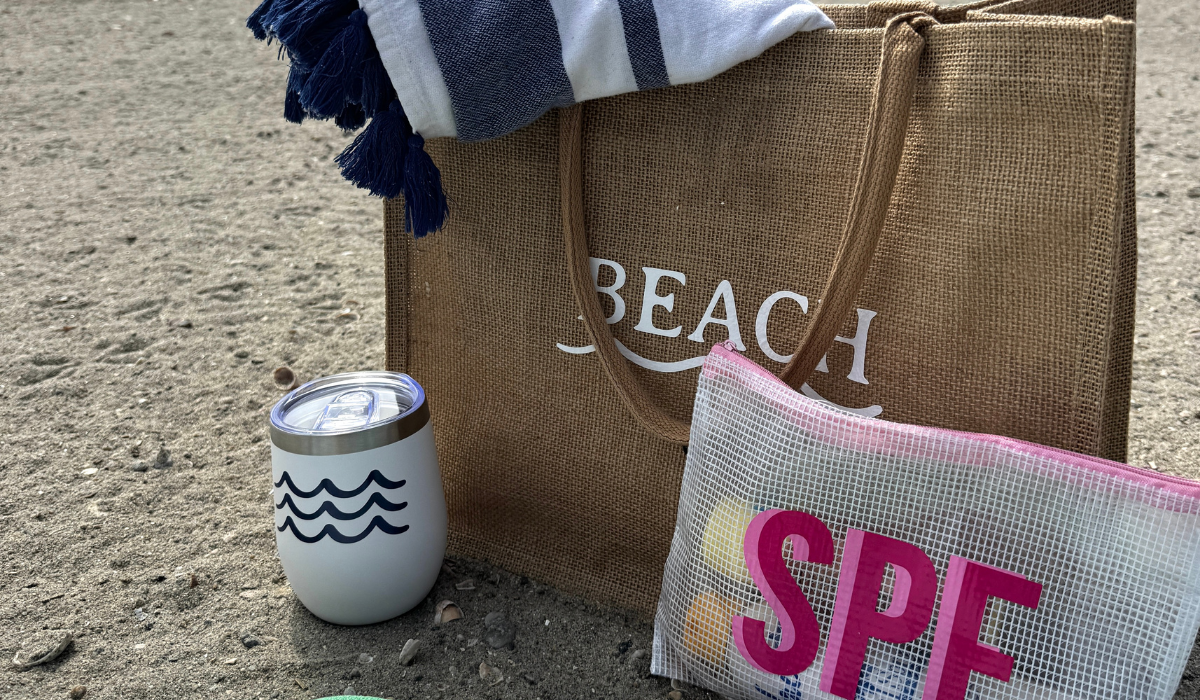 Beach bag, tumbler, and pouch with 'SPF' on sand