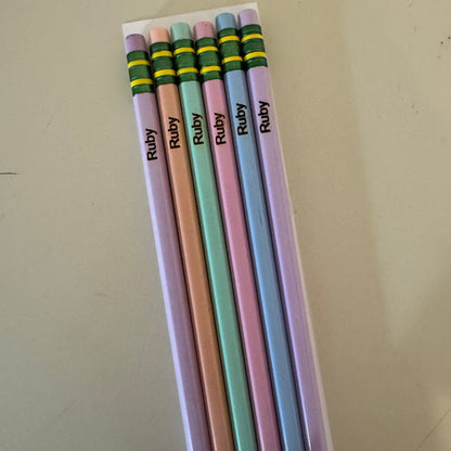 Set of colorful pencils with 'Ruby' branding on a beige surface